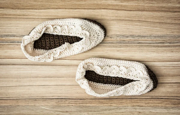 Brown knitted slippers on the wooden background — Stock Photo, Image