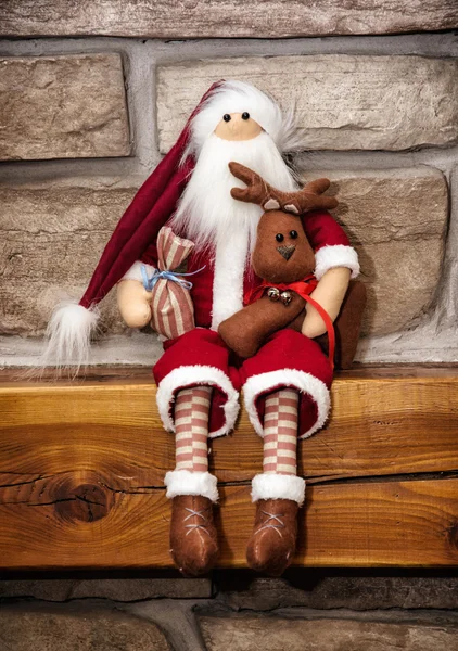 Santa claus made of cloth is sitting with reindeer over the ston — Stock Photo, Image