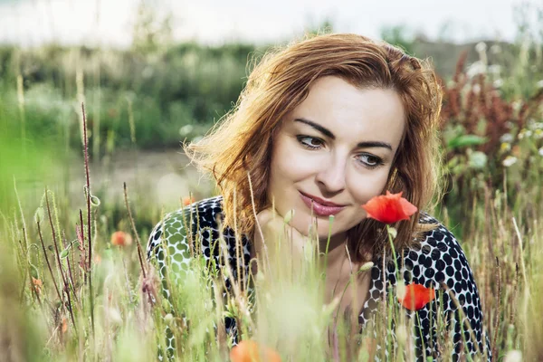 Hermosa mujer caucásica posando con flores de amapola campo, summe —  Fotos de Stock