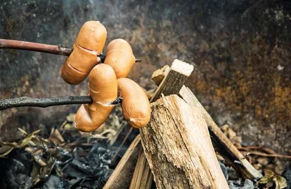 Grilla korv vid lägerelden, utomhusaktivitet — Stockfoto