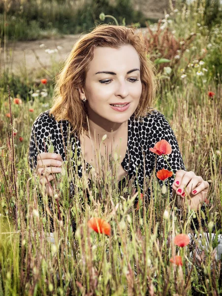 Vacker kvinna poserar i vallmo blommor fält, skönhet, mode en — Stockfoto