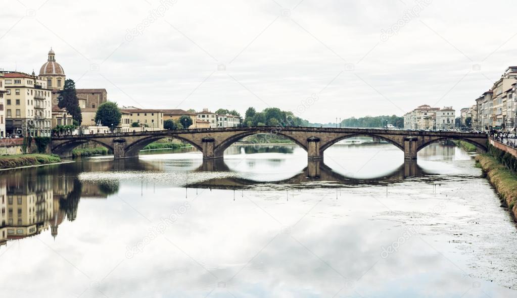 Beautiful Ponte Santa Trinita is mirrored in the river Arno, Flo