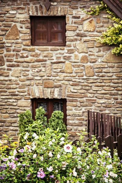 Altes Backsteinhaus, Holzzaun und Hibiskusblumen — Stockfoto