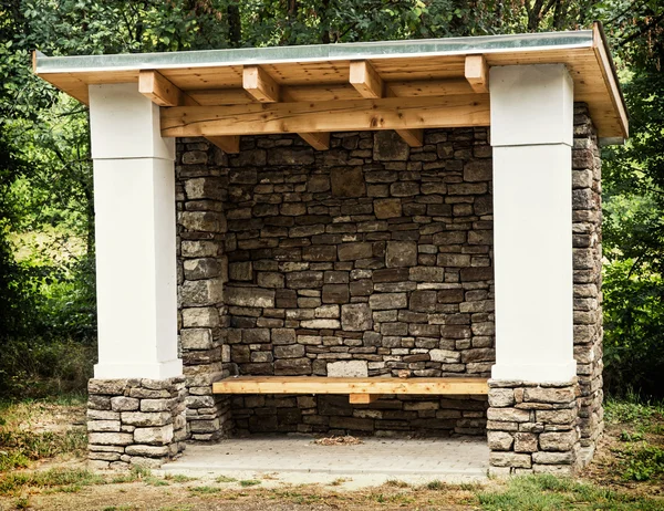 Rural bus stop of stone and wood — Stock Photo, Image