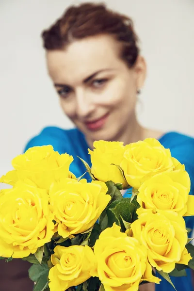 Jovem morena posando com rosas amarelas, beleza e moda — Fotografia de Stock