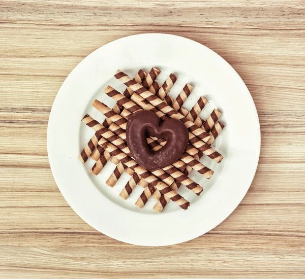 Rolos de chocolate e biscoito de gengibre em forma de coração, símbolo de l — Fotografia de Stock