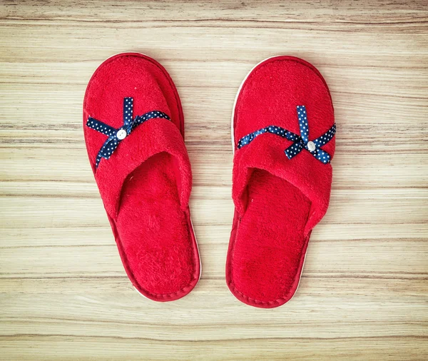 Red slippers with blue ribbon on the wooden background, retro st — Stock Photo, Image