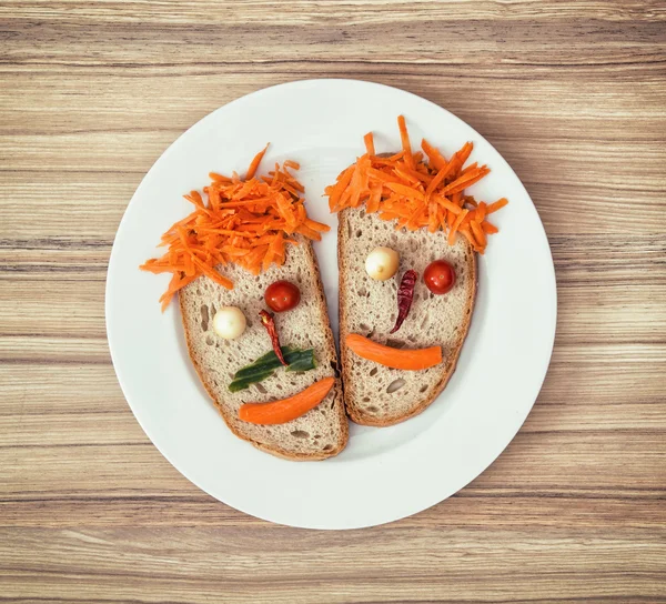 Plantaardige gezichten gemaakt van brood, kaas, Spaanse peper, tomaten en carr — Stockfoto