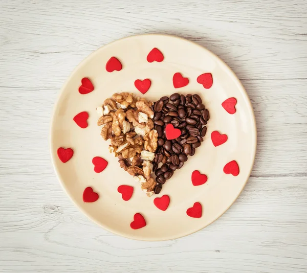 Forma corazón de granos de café y nueces peladas con muchos pequeños —  Fotos de Stock