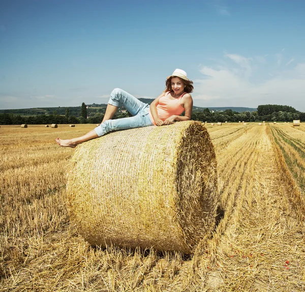 Junge Frau liegt auf einem Stapel Stroh — Stockfoto