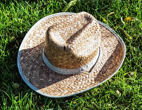 Sombrero de paja amarillo del granjero en la hierba —  Fotos de Stock