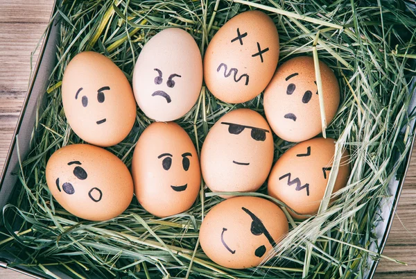 Эмоциональные крашеные яйца в коробке с сеном — стоковое фото