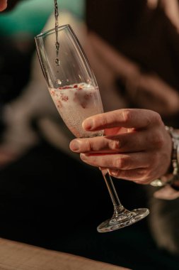 Sevgililer Günü kutlamanız kutlu olsun. Kırmızı kalp şeklindeki konfetiyle şampanya dolduran adam. Bardakta aşk iksiri. Kapat.