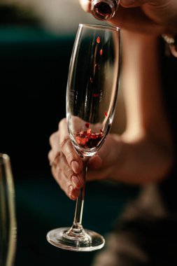 Sevgililer Günü kutlamanız kutlu olsun. Adam kadınlara aşk iksiri dolduruyor. Boş şampanya kadehi. Kırmızı Kalp cam konfeti şeklinde. Kapat.