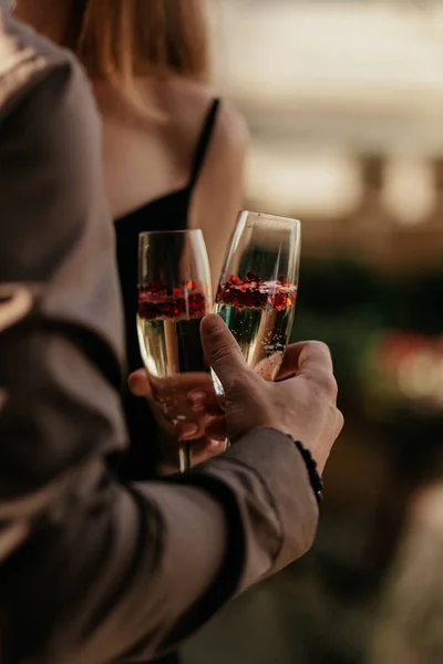 Para zakochanych, trzymająca kieliszki z musującym szampanem i czerwonym konfetti w kształcie serca. Koncepcja ślubu, dzień kochanków. Wesołych Walentynek. Zamknij się. — Zdjęcie stockowe