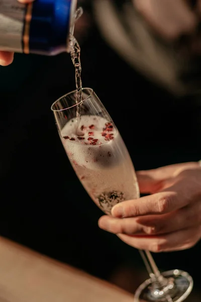 Wesołych Walentynek. Człowiek nalewający musującego szampana do szklanki z czerwonym konfetti w kształcie serca. Miłosny eliksir w szkle. Zamknij się. — Zdjęcie stockowe