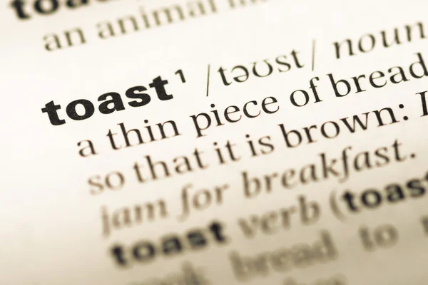 단어 토스트와 함께 오래 된 영어 사전 페이지 닫습니다 — 스톡 사진
