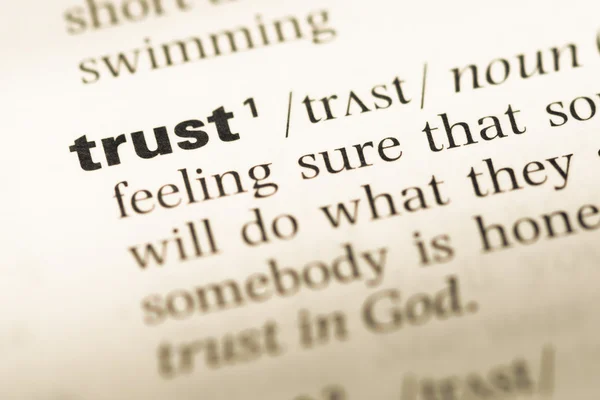 Close up of old English dictionary page with word trust — Stock Photo, Image