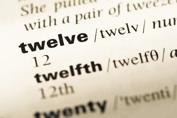 Primer plano de la página del diccionario inglés antiguo con la palabra doce —  Fotos de Stock