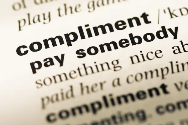 Zblízka staré stránky anglického slovníku slovo kompliment — Stock fotografie
