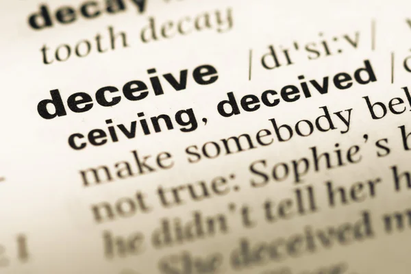 Close up of old English dictionary page with word deceive — Stock Photo, Image