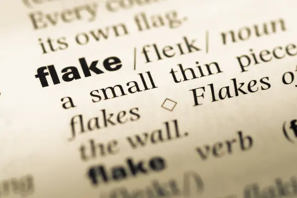 Primer plano de la página del diccionario inglés antiguo con la palabra flake — Foto de Stock