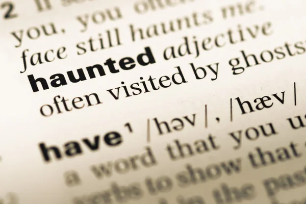 Close up of old English dictionary page with word haunted — Stock Photo, Image