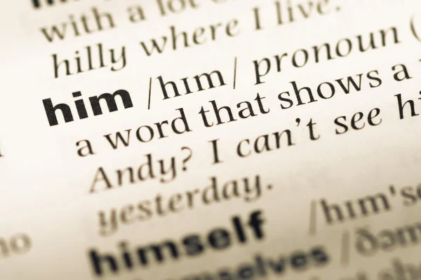 Close up of old English dictionary page with word him — Stock Photo, Image