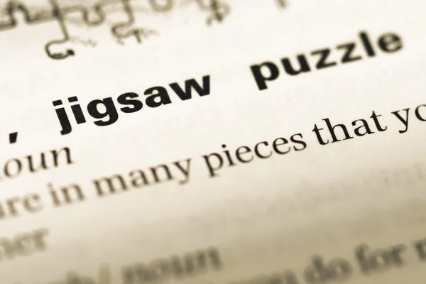 Close up of old English dictionary page with word jigsaw puzzle — Stock Photo, Image