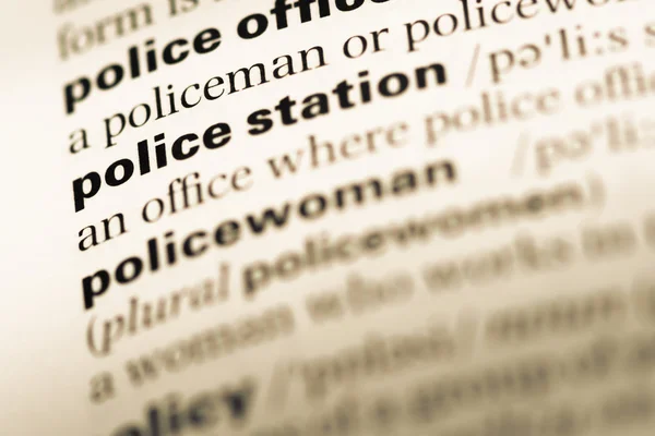 Close up of old English dictionary page with word police station — Stock Photo, Image