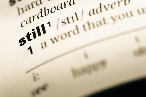 Close up of old English dictionary page with word still — Stock Photo, Image