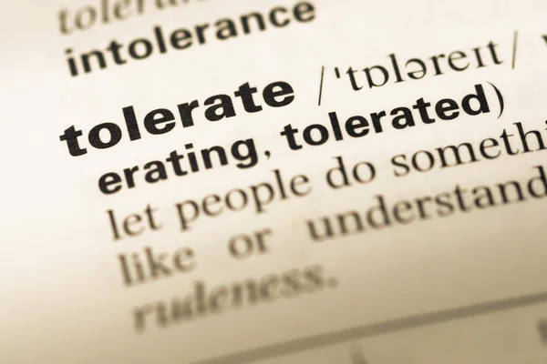 Close up of old English dictionary page with word tolerate — Stock Photo, Image