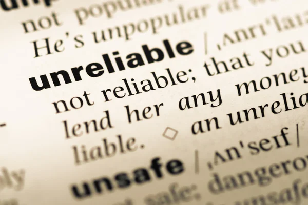 Close up of old English dictionary page with word unreliable — Stock Photo, Image