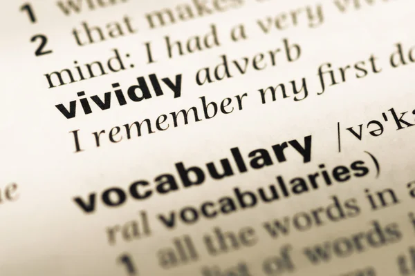 Close up of old English dictionary page with word vividly — Stock Photo, Image