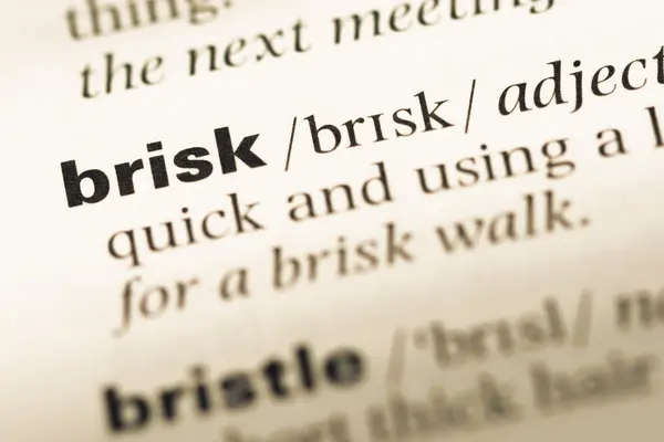 Close up of old English dictionary page with word brisk — Stock Photo, Image