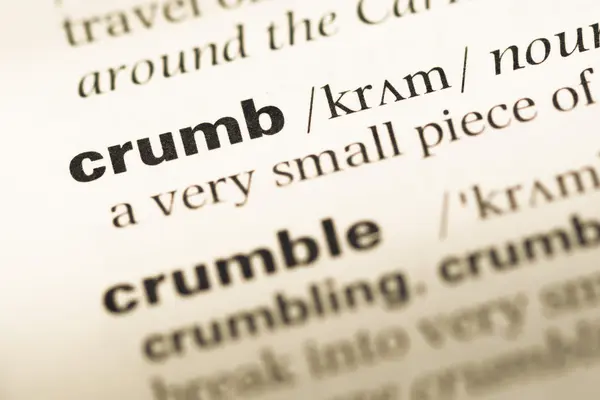 Close up of old English dictionary page with word crumb — Stock Photo, Image