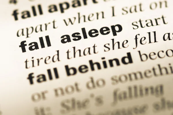 Close up of old English dictionary page with word fall asleep — Stock Photo, Image