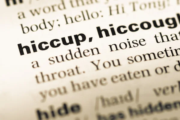 Close up of old English dictionary page with word hiccup — Stock Photo, Image