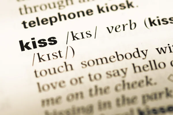 Gros plan sur la vieille page du dictionnaire anglais avec word kiss — Photo