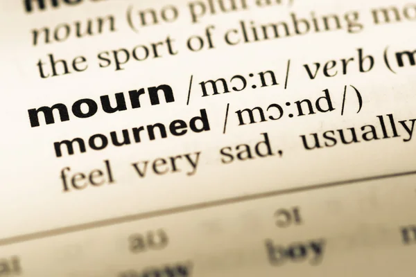 Close up of old English dictionary page with word mourn — Stock Photo, Image