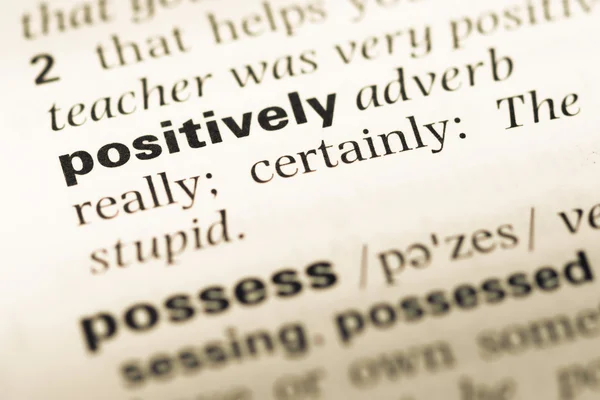 Close up of old English dictionary page with word positively — Stock Photo, Image