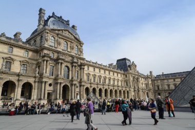 PARIS - APRIL 10: People go to famous Louvre museum on April 10, 2013 in Paris, France. Louvre is the most visited museum in the world, more 10 millions in 2012.