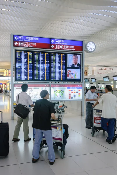 HONG KONG, CHINA - FEVEREIRO 11: Passageiros no lobby principal do aeroporto em 11 de fevereiro de 2013 em Hong Kong, China. O aeroporto de Hong Kong lida com mais de 70 milhões de passageiros por ano . — Fotografia de Stock