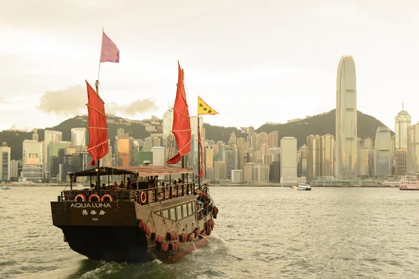 HONG KONG - 15 SEPTEMBRE : Port de Victoria le 15 septembre 2013 à Hong Kong. Une vieille jonque chinoise a quitté Ocean Terminal et a traversé le port de Victoria au coucher du soleil . — Photo