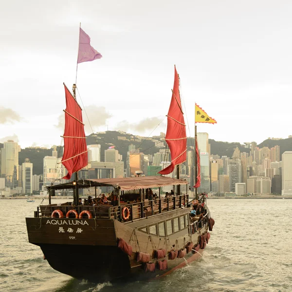 HONG KONG - 15 SEPTEMBRE : Port de Victoria le 15 septembre 2013 à Hong Kong. Une vieille jonque chinoise a quitté Ocean Terminal et a traversé le port de Victoria au coucher du soleil . — Photo