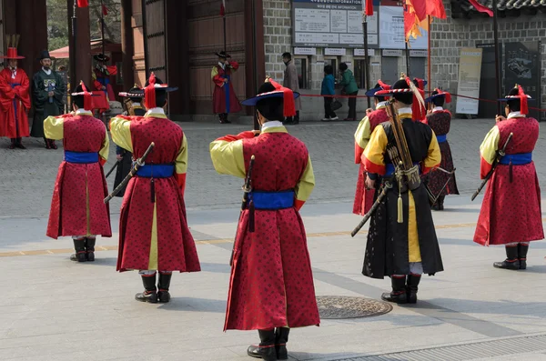 SEÚL, COREA - 01 DE MARZO: Soldados armados en traje de época custodian la puerta de entrada en el Palacio Deoksugung, un punto de referencia turístico, en Seúl, Corea del Sur el 01 de marzo de 2013 — Foto de Stock