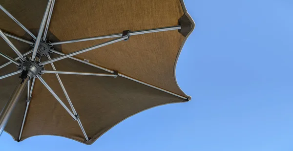 Patio umbrella against sunny blue sky