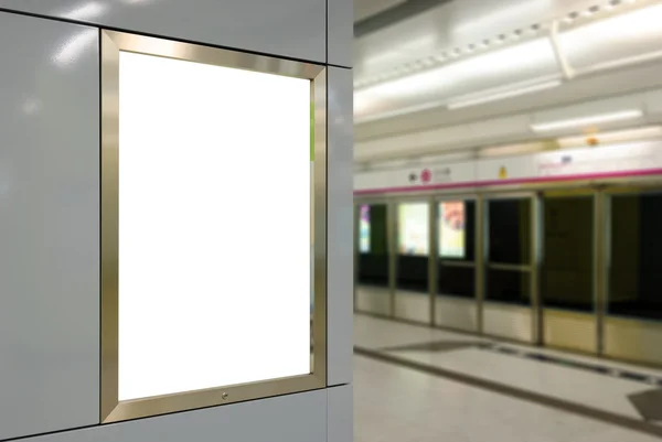 Ένα μεγάλο κάθετο/κατακόρυφου προσανατολισμού κενή πινακίδα στο σύγχρονο λευκό τοίχο με φόντο πλατφόρμα μετρό — Φωτογραφία Αρχείου