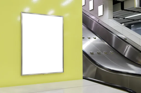 Ένα μεγάλο κάθετο/κατακόρυφου προσανατολισμού κενή πινακίδα στο σύγχρονο κίτρινο τοίχο με φόντο κυλιόμενες σκάλες — Φωτογραφία Αρχείου