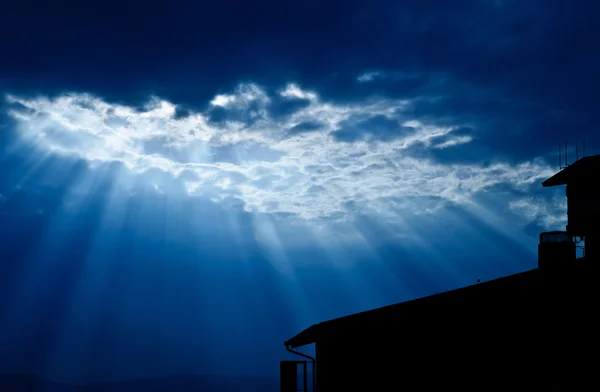 Light form the sky shining down on house / Crepuscular rays / Jesus light with house in deep blue sky